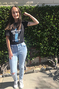 Smiling woman posing with flexed arm outdoors