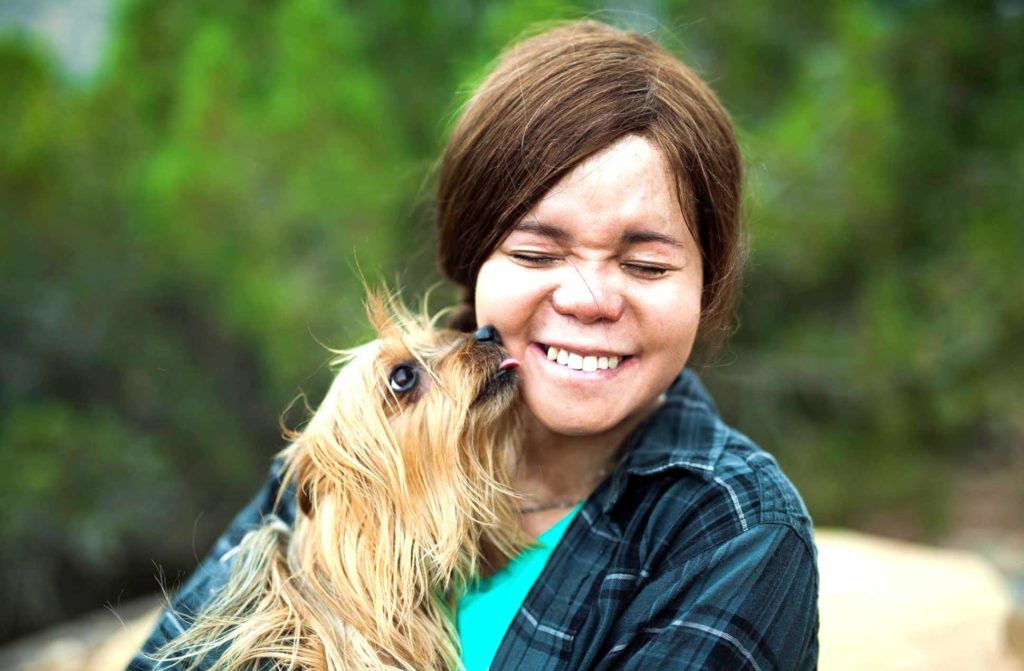 Smiling woman holding a small dog
