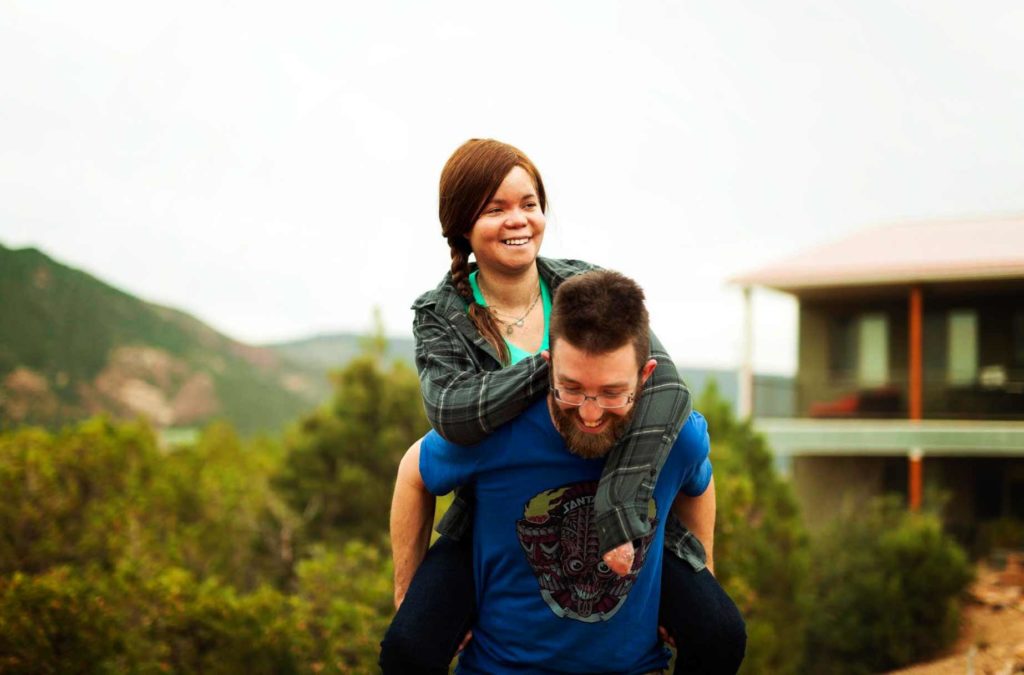 Image of Smiling woman on a man’s back